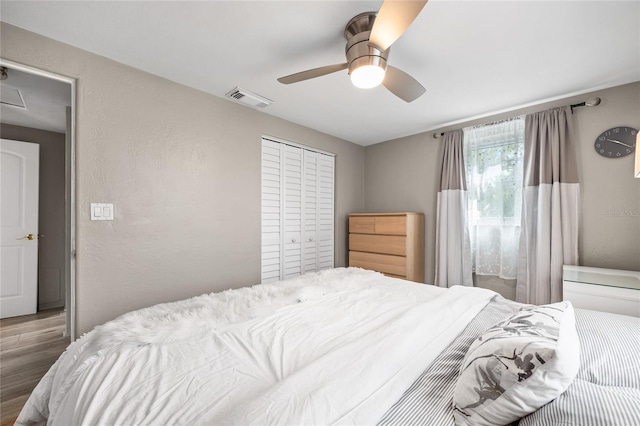 bedroom with wood finished floors, a closet, and a ceiling fan