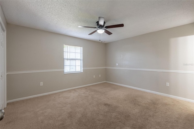 spare room with a ceiling fan, carpet flooring, a textured ceiling, and baseboards