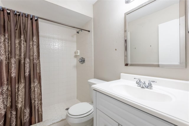 bathroom with toilet, vanity, and a stall shower