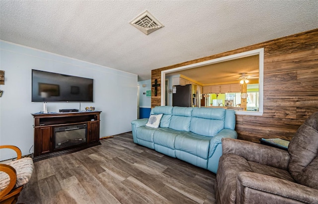6111 2nd Ave, New Port Richey, FL 34653 - living area with wood finished floors, wood walls, a ceiling fan, and a textured ceiling