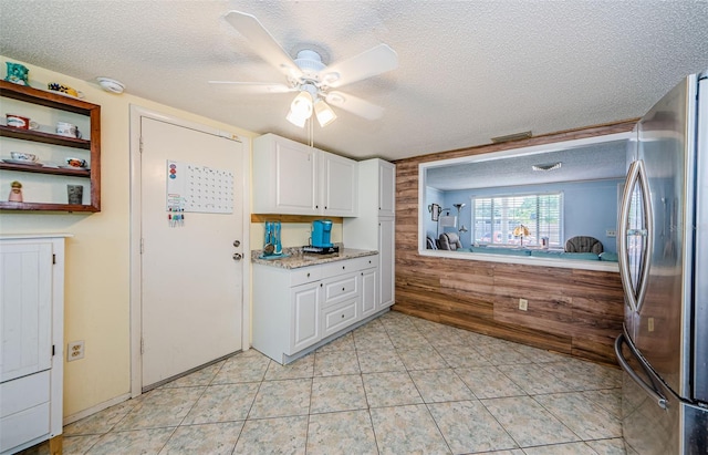6111 2nd Ave, New Port Richey, FL 34653 - kitchen with freestanding refrigerator, a textured ceiling, white cabinets, a ceiling fan, and light tile patterned floors
