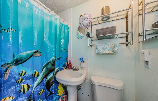 6111 2nd Ave, New Port Richey, FL 34653 - bathroom with toilet and a textured ceiling
