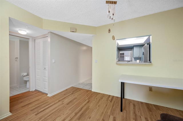1100 E Bay Dr Unit 60, Largo, FL 33770 - unfurnished dining area with light wood-style floors, baseboards, and a textured ceiling