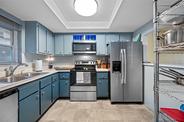 1100 E Bay Dr Unit 60, Largo, FL 33770 - kitchen with stainless steel appliances, a sink, a tray ceiling, blue cabinetry, and light countertops