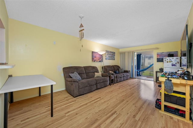 1100 E Bay Dr Unit 60, Largo, FL 33770 - living area with light wood-style floors, a textured ceiling, and baseboards