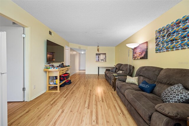 1100 E Bay Dr Unit 60, Largo, FL 33770 - living room with light wood finished floors, a textured ceiling, and baseboards