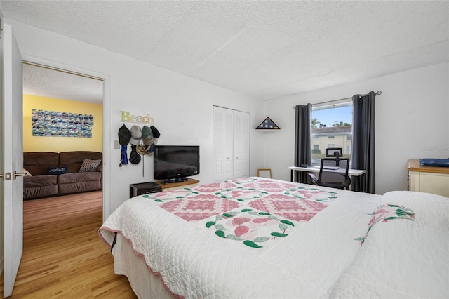 1100 E Bay Dr Unit 60, Largo, FL 33770 - bedroom with light wood finished floors, a textured ceiling, and a closet