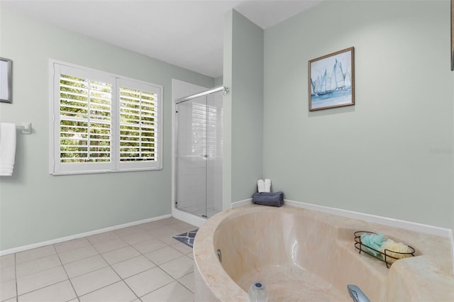 bathroom featuring a shower stall, a garden tub, tile patterned floors, and baseboards