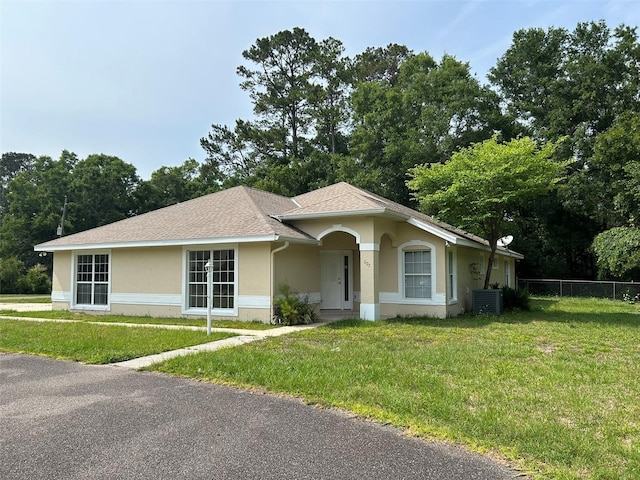 607 NE 10th Blvd, Williston, FL 32696 - single story home featuring stucco siding, cooling unit, view of wooded area, and roof with shingles