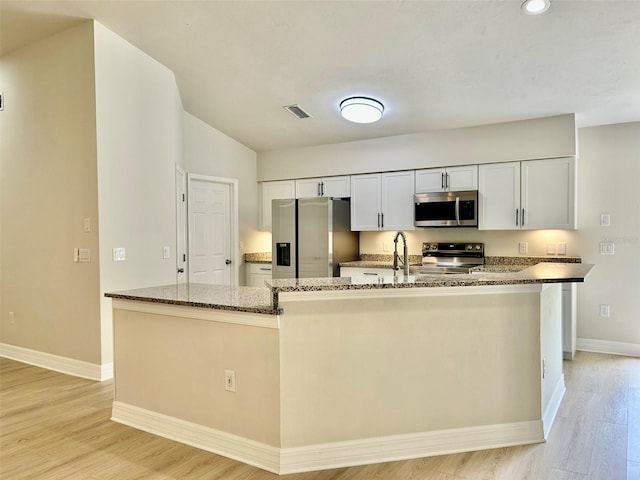 607 NE 10th Blvd, Williston, FL 32696 - kitchen with stainless steel appliances, baseboards, dark stone counters, light wood finished floors, and recessed lighting