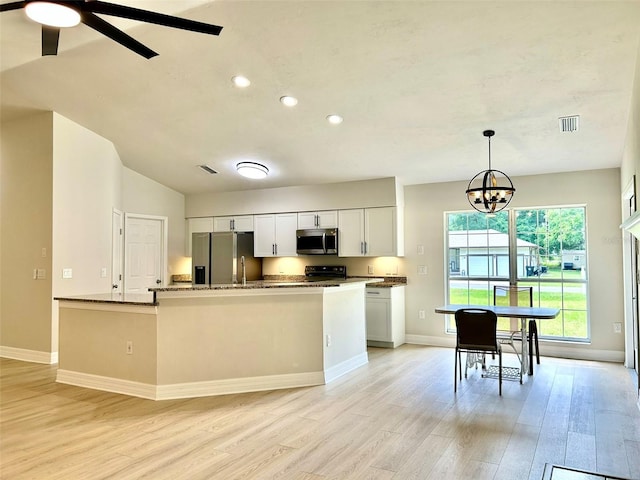 607 NE 10th Blvd, Williston, FL 32696 - kitchen with stainless steel appliances, light wood-style floors, recessed lighting, baseboards, and a chandelier