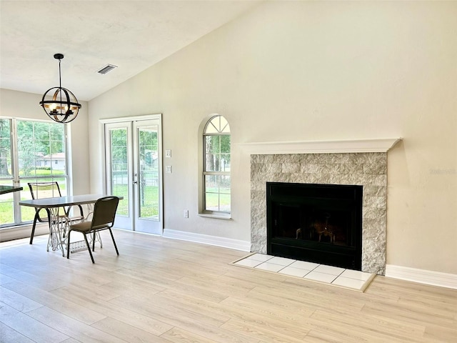 607 NE 10th Blvd, Williston, FL 32696 - dining room featuring lofted ceiling, wood finished floors, a chandelier, baseboards, and a tile fireplace