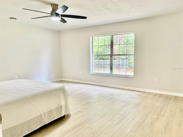 607 NE 10th Blvd, Williston, FL 32696 - unfurnished bedroom with light wood-style flooring, baseboards, and ceiling fan