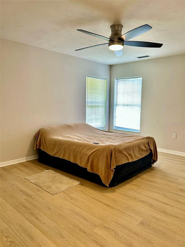 607 NE 10th Blvd, Williston, FL 32696 - bedroom with baseboards, wood finished floors, and a ceiling fan