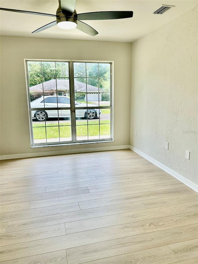 607 NE 10th Blvd, Williston, FL 32696 - spare room with a ceiling fan, light wood-style floors, a textured wall, and baseboards