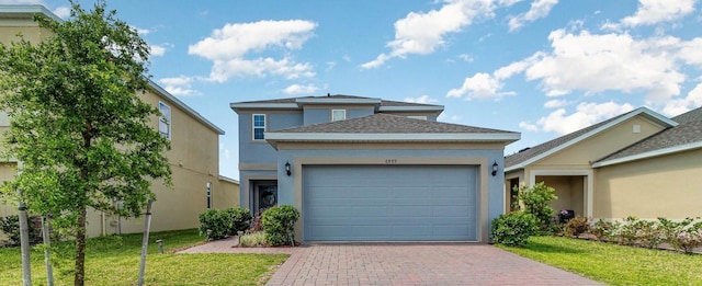 6889 Wilson Hammock Ave, Groveland, FL 34736 - view of front of home featuring stucco siding, a garage, decorative driveway, a front lawn, and a shingled roof