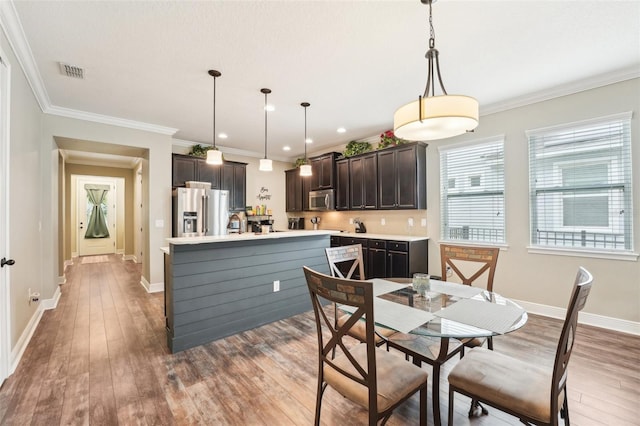 dining space featuring wood-type flooring, baseboards, recessed lighting, and ornamental molding