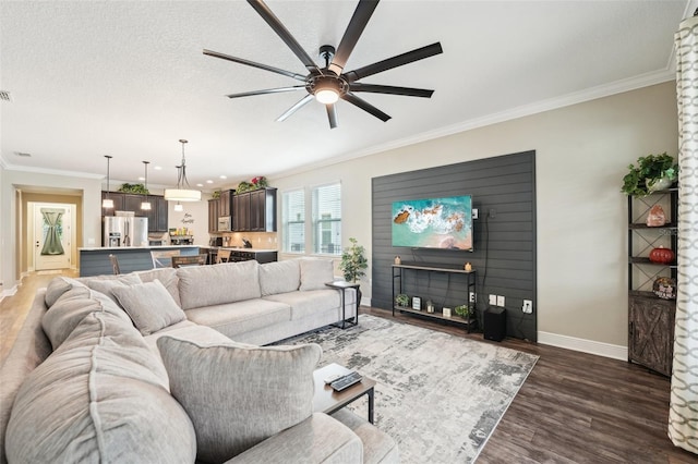 living area featuring baseboards, dark wood-style floors, crown molding, ceiling fan, and a fireplace
