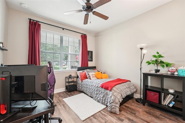 bedroom with wood finished floors, baseboards, and a ceiling fan