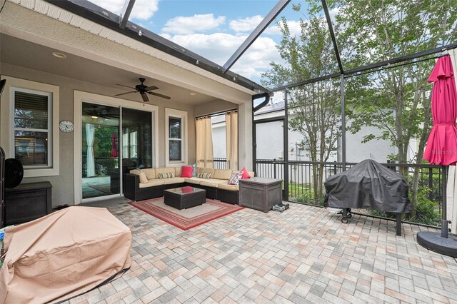 view of patio featuring an outdoor living space, glass enclosure, ceiling fan, and a grill