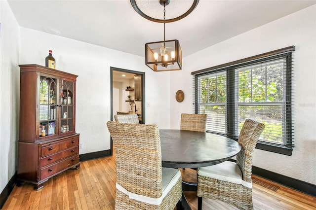 233 24th St N, Saint Petersburg, FL 33713 - dining space with light wood-style floors, a chandelier, and plenty of natural light