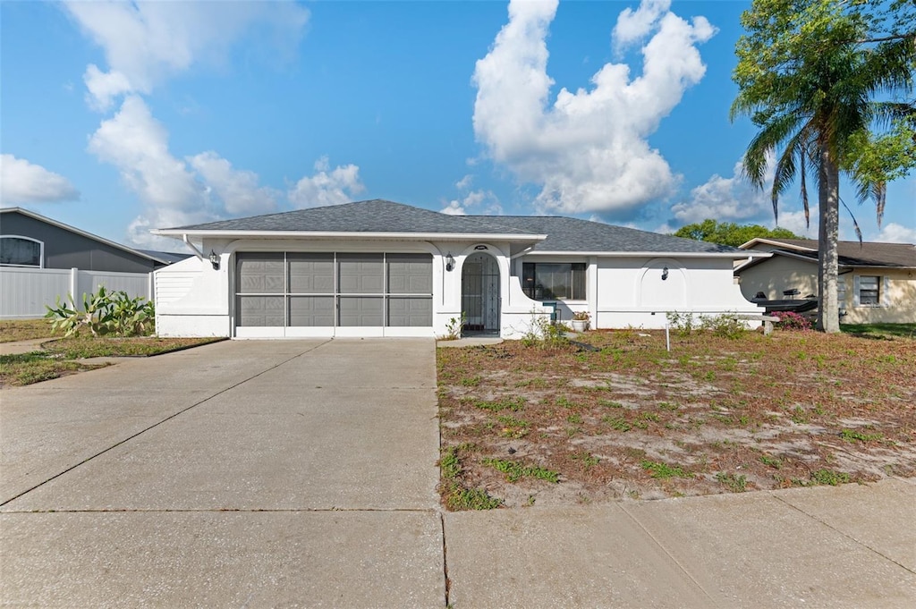 11305 Brown Bear Ln, Port Richey, FL 34668 - ranch-style house with concrete driveway, stucco siding, an attached garage, and fence
