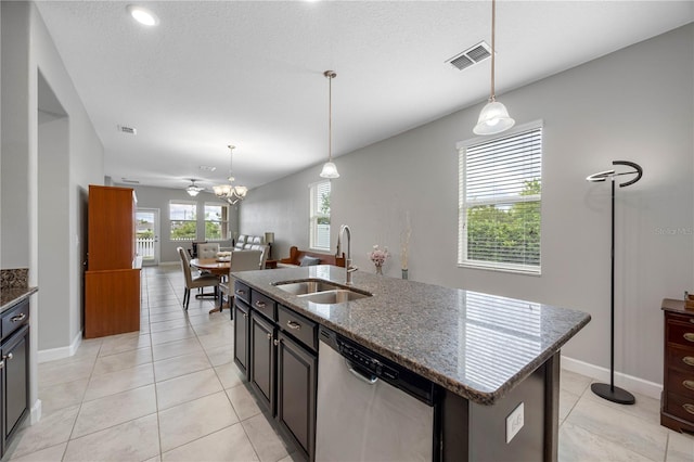 kitchen featuring dishwasher, a sink, hanging light fixtures, light tile patterned flooring, and baseboards