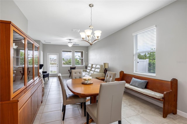 dining room with a chandelier, light tile patterned flooring, ceiling fan, and baseboards