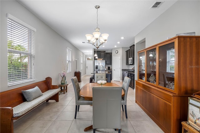 dining area with a chandelier, light tile patterned flooring, and recessed lighting