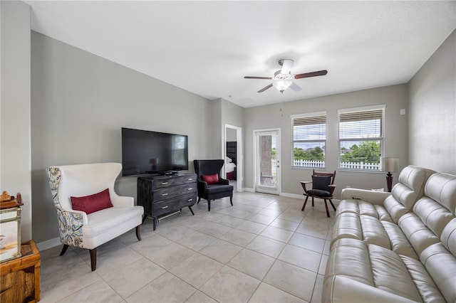 living room with a ceiling fan, light tile patterned flooring, and baseboards