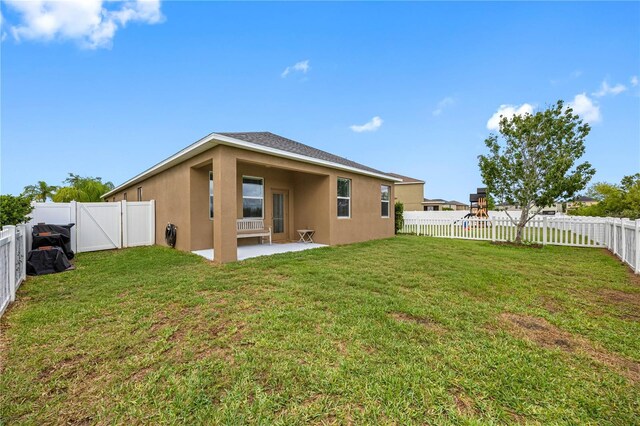 back of property with stucco siding and a patio