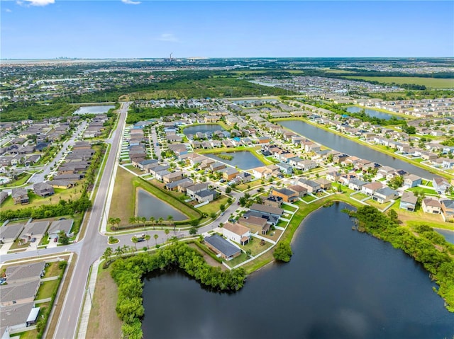 aerial view of property and surrounding area featuring nearby suburban area and a large body of water