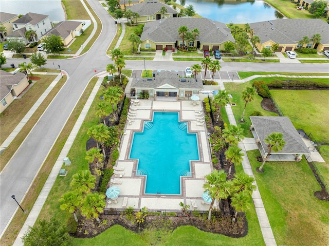 aerial view of residential area featuring a pool area and a nearby body of water