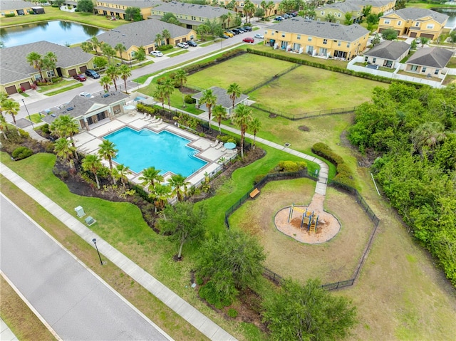aerial perspective of suburban area featuring a pool area and a nearby body of water