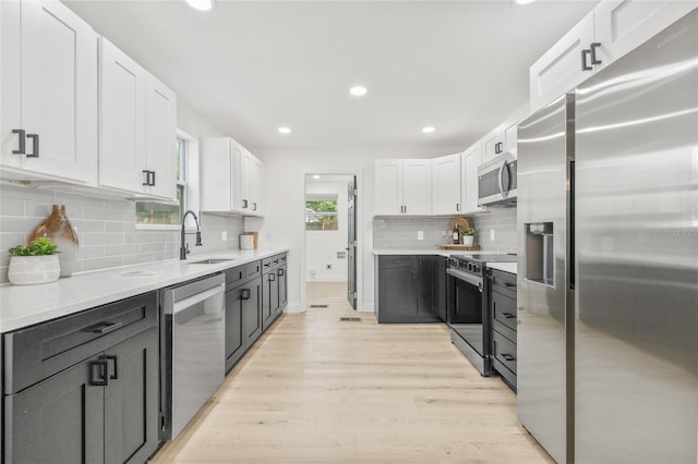 7 Hamilton Heath Dr, Tampa, FL 33604 - kitchen featuring appliances with stainless steel finishes, a sink, white cabinetry, light wood-type flooring, and light countertops