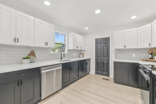 7 Hamilton Heath Dr, Tampa, FL 33604 - kitchen featuring stainless steel appliances, a sink, white cabinets, recessed lighting, and light wood-style floors