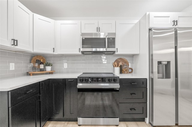 7 Hamilton Heath Dr, Tampa, FL 33604 - kitchen featuring stainless steel appliances, white cabinets, light countertops, and dark cabinetry