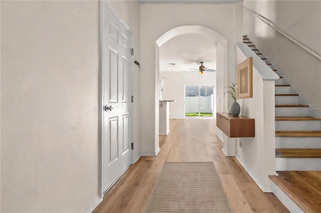 568 Shoreham Ct NE, Saint Petersburg, FL 33716 - hall with arched walkways, light wood-style floors, stairs, and baseboards