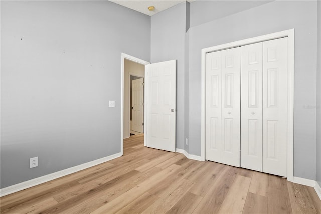 568 Shoreham Ct NE, Saint Petersburg, FL 33716 - unfurnished bedroom with light wood-style flooring, baseboards, and a closet