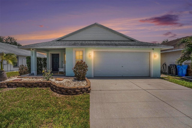 ranch-style house featuring driveway, an attached garage, a front lawn, and stucco siding