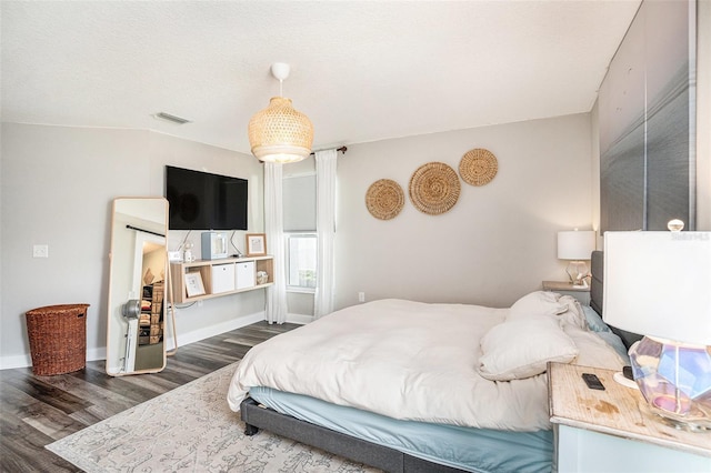 bedroom featuring dark wood-style floors and baseboards