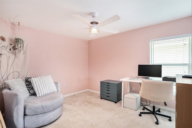 office featuring light carpet, ceiling fan, and baseboards
