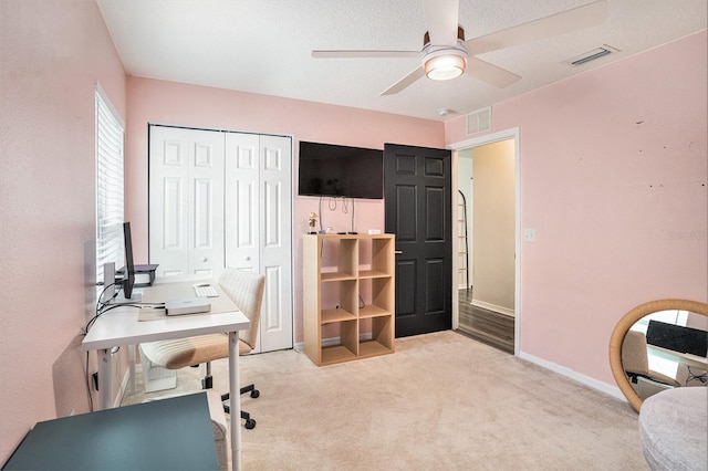 office space with ceiling fan, light colored carpet, and baseboards