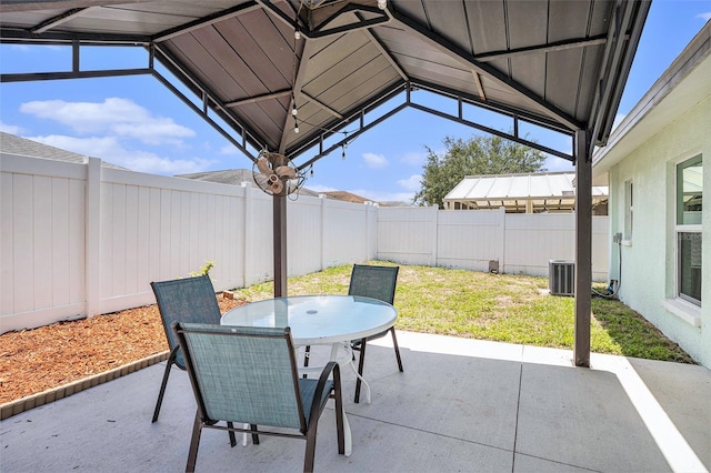 view of patio featuring outdoor dining space, a fenced backyard, and central air condition unit