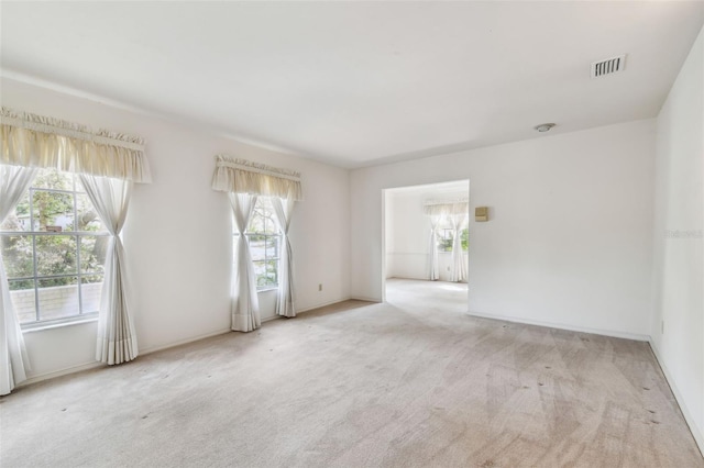 carpeted empty room featuring plenty of natural light and baseboards