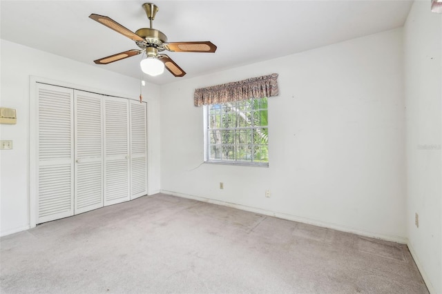 unfurnished bedroom with carpet, a closet, baseboards, and a ceiling fan