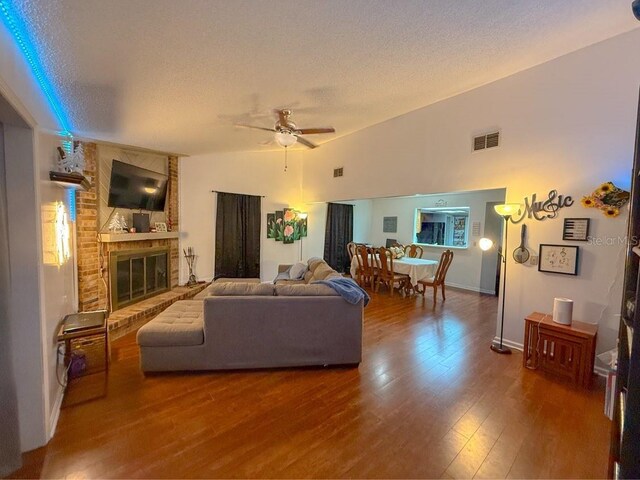 35058 Whispering Oaks Blvd, Dade City, FL 33523 - living area with wood finished floors, a textured ceiling, ceiling fan, a brick fireplace, and lofted ceiling