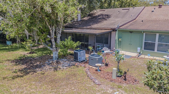 35058 Whispering Oaks Blvd, Dade City, FL 33523 - rear view of house featuring central AC, a sunroom, and a shingled roof