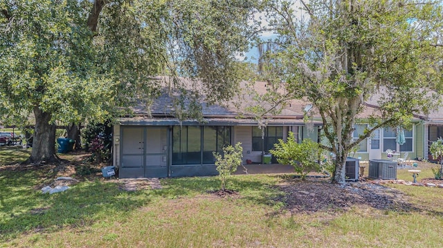 35058 Whispering Oaks Blvd, Dade City, FL 33523 - rear view of house with a sunroom, a yard, and cooling unit