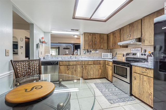 35058 Whispering Oaks Blvd, Dade City, FL 33523 - kitchen featuring stainless steel appliances, under cabinet range hood, a sink, and light countertops